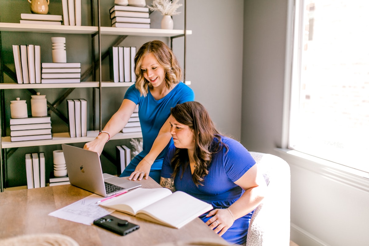 Foto real de duas empreendedoras organizando o negócio juntas num laptop